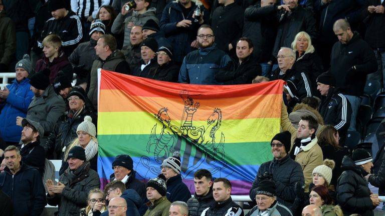 Newcastle United fans hold up a rainbow flag at St James' Park in support of the Rainbow Laces campaign