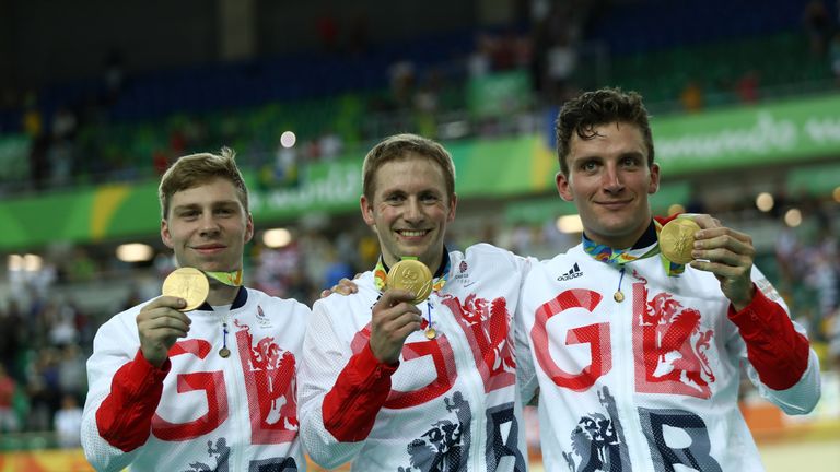 Olympic gold medalists Philip Hindes, Jason Kenny and Callum Skinner of Great Britain celebrate on the podium after winning the men's team sprint in Rio