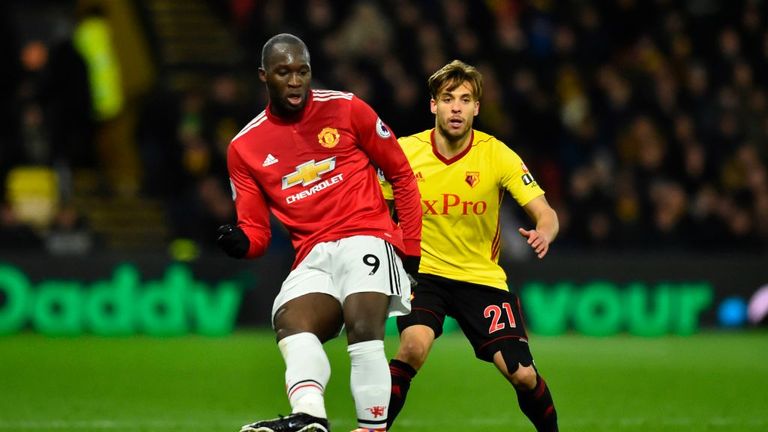 Manchester United's Belgian striker Romelu Lukaku (L) plays the ball away from Watford's Spanish defender Kiko Femenia (R)