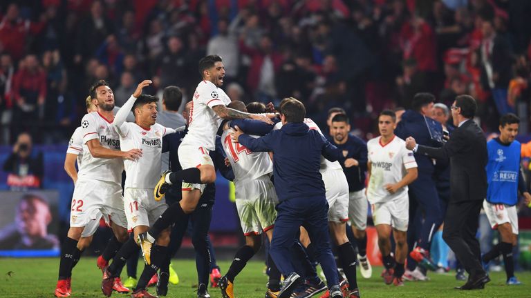 Sevilla's Guido Pizarro celebrates with team-mates and coaches