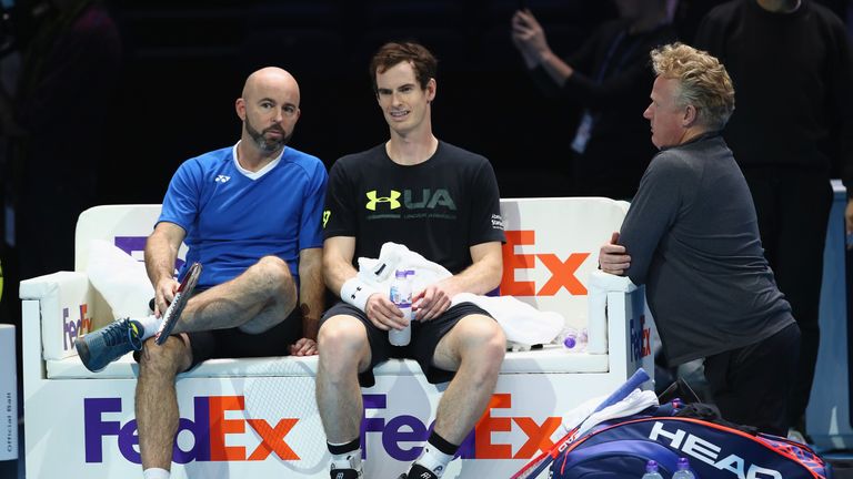 Andy Murray of Great Britain and coach Jamie Delgado talk as physio Mark Bender listens