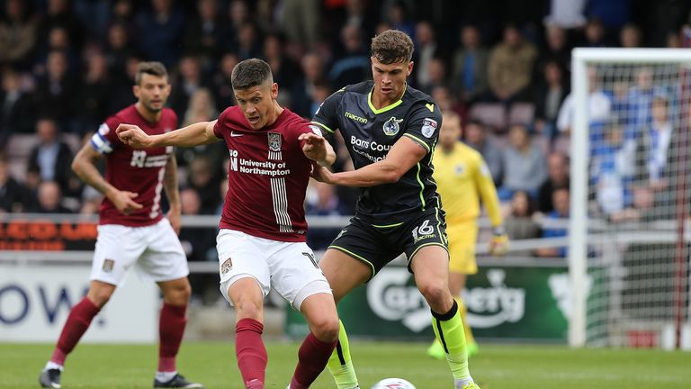 NORTHAMPTON, ENGLAND - OCTOBER 07:  Alex Revell of Northampton Town plays the ball under pressure from Tom Broadbent of Bristol Rovers during the Sky Bet L