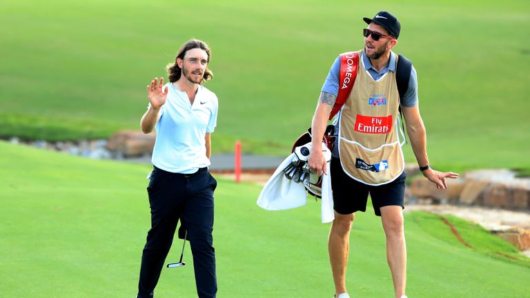 DUBAI, UNITED ARAB EMIRATES - NOVEMBER 18:  Tommy Fleetwood of England acknowledges the crowd on the 18th hole with caddie Ian Finnis during the third roun