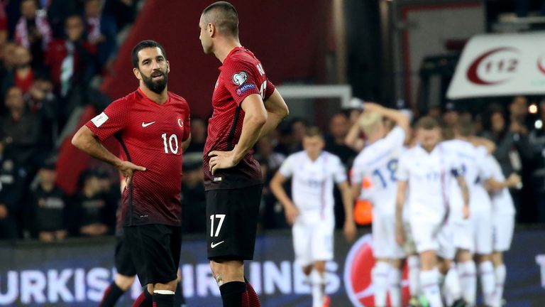 Turkey's Arda Turan (L) and Burak Yilmaz reacts as Iceland's players celebrate scoring their second goal during the FIFA World Cup 2018 qualification footb