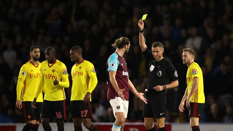 Match referee Andre Marriner (second right) books West Ham United's Andy Carroll (centre) during the Premier League match at Watford.