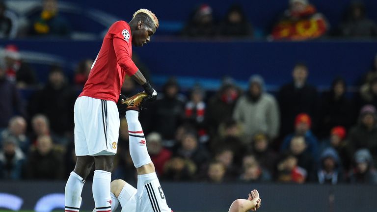 Manchester United midfielder Paul Pogba assists defender Luke Shaw, stricken by cramp during the UEFA Champions League game against CSKA Moscow