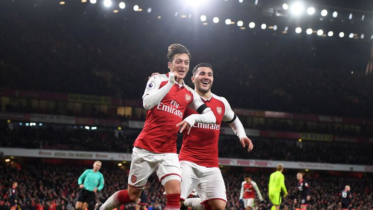 Mesut Ozil celebrates with Sead Kolasinac after scoring for Arsenal against Huddersfield Town at Emirates Stadium on November 29, 2017 in London, England