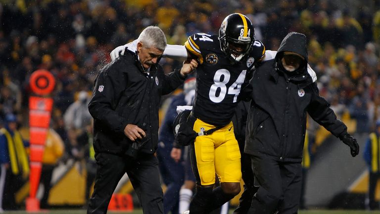 PITTSBURGH, PA - DECEMBER 17: Antonio Brown #84 of the Pittsburgh Steelers is walked off the field by trainers after landing awkwardly while attempting to 