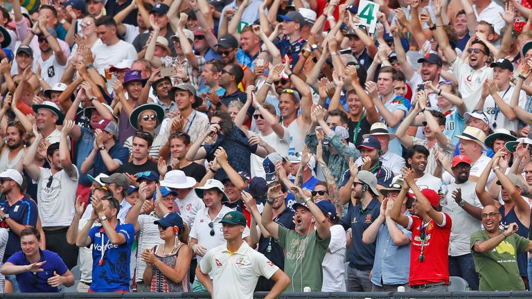 The Barmy Army celebrate in the crowd as  Jackson Bird of Australia looks on during day three of the Fourth Test