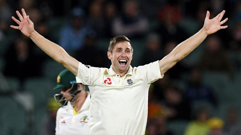 England's paceman Chris Woakes celebrates dismissing Australia's batsman Steve Smith (L) on the third day of the second Ashes cricket Test match in Adelaid