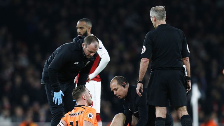 Jordan Henderson receives treatment on the pitch during the Premier League match between Arsenal and Liverpool