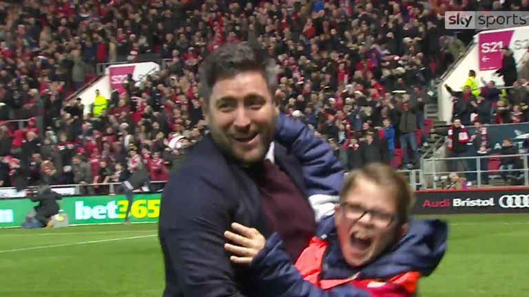 Lee Johnson celebrates Bristol City's match-winning goal against Manchester United with a ball boy