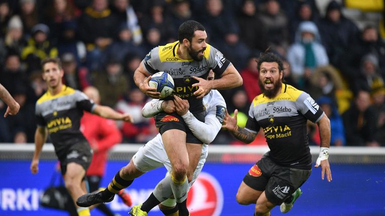 La Rochelle's Geoffrey Doumayrou (C) is tackled as he runs with the ball during the European Rugby Champions Cup rugby union match between La Rochelle and 