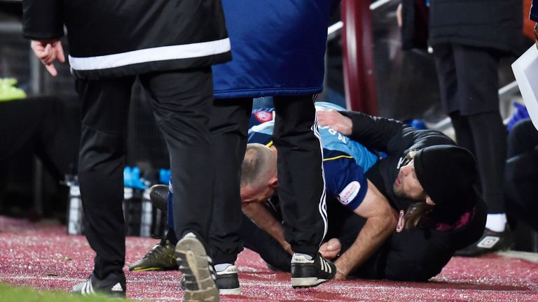Hearts assistant manager Austin MacPhee (in hat) and Accies' Darian MacKinnon grapple on the ground