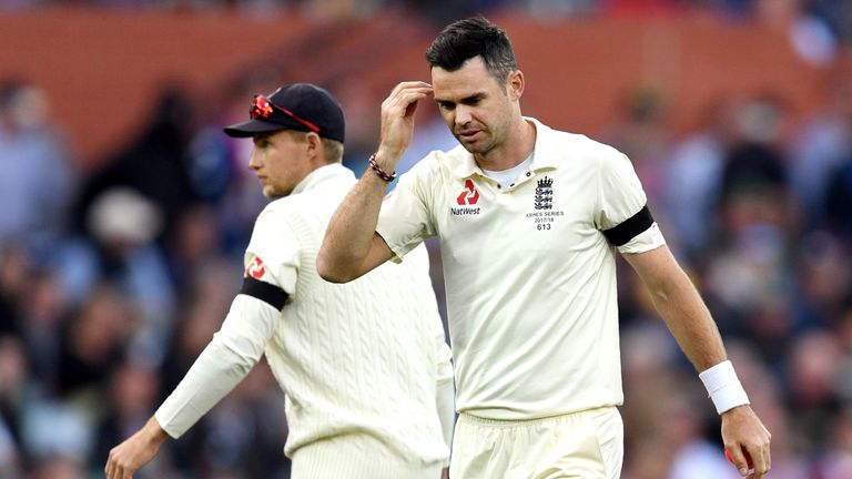 England's James Anderson (R) prepares to send down a delivery to Australia as captain Joe Root (L) looks away on the first day of the second Ashes cricket 