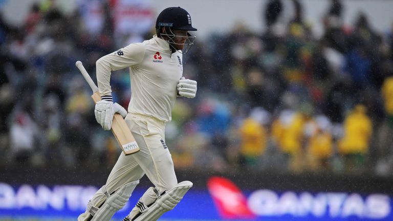 England's Jonny Bairstow runs off the field as rain halts play on day four of the third Ashes cricket Test match between England and Australia in Perth on 