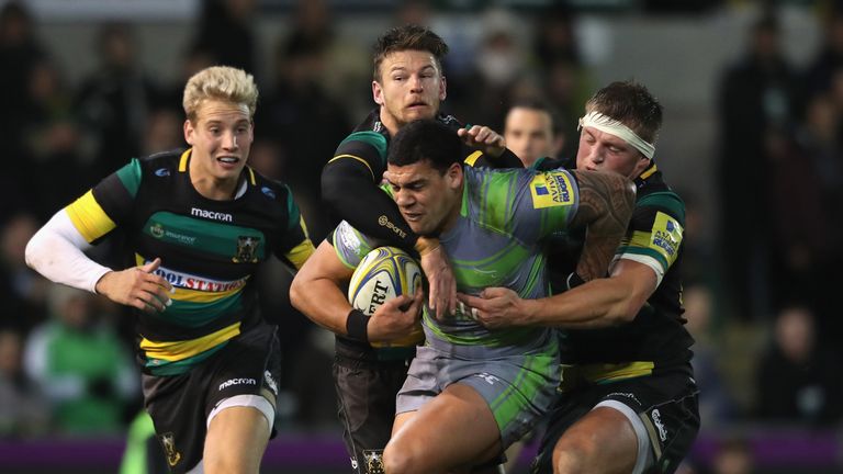 Josh Matavesi of Newcastle holds off Rob Horne (L) and Alex Waller to score 