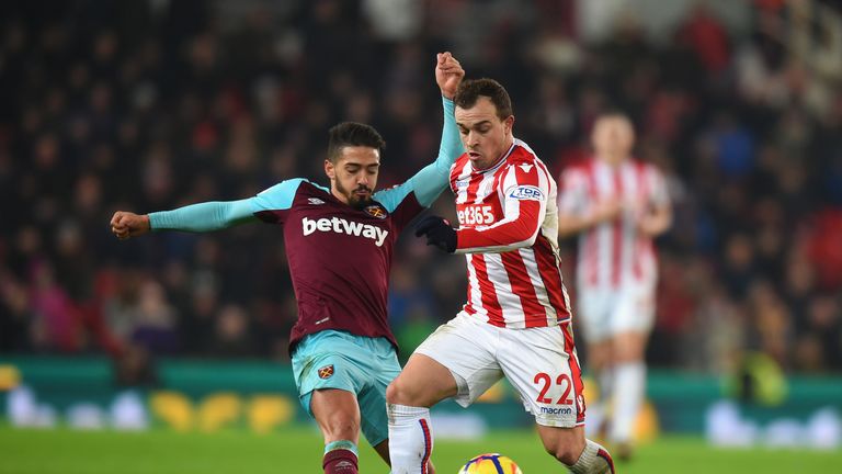 STOKE ON TRENT, ENGLAND - DECEMBER 16:  Xherdan Shaqiri of Stoke City is tackled by Manuel Lanzini of West Ham United during the Premier League match betwe