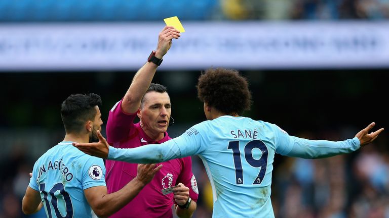 MANCHESTER, ENGLAND - SEPTEMBER 23: Leroy Sane of Manchester City is shown a yellow card by referee Neil Swarbrick during the Premier League match between 