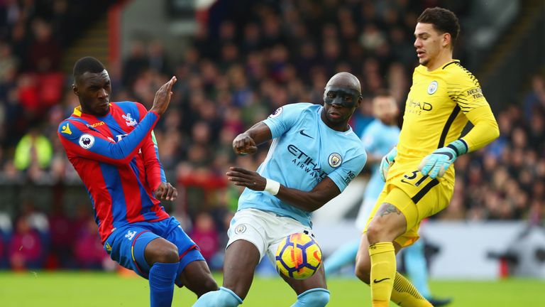Christian Benteke of Crystal Palace is foiled by Eliaquim Mangala and Ederson of Manchester City during the Premier League match