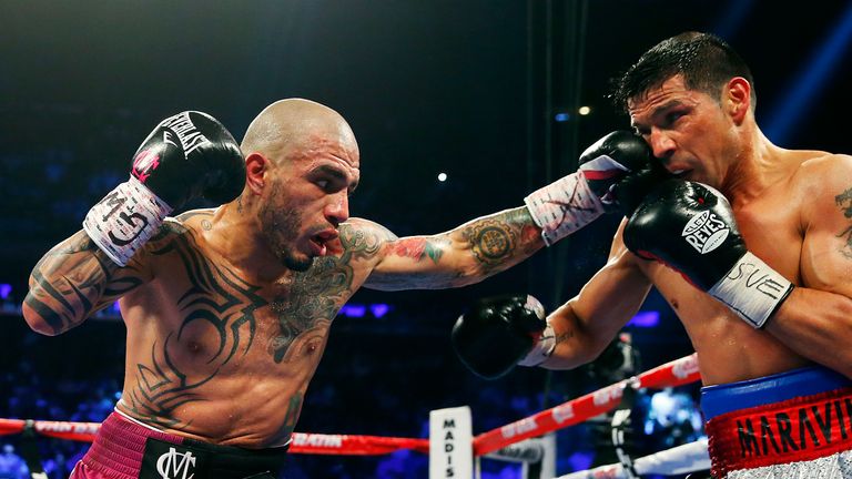  Miguel Cotto of Puerto Rico lands a left punch to the face of Sergio Martinez of Argentina during the third round of the WBC Middleweight title