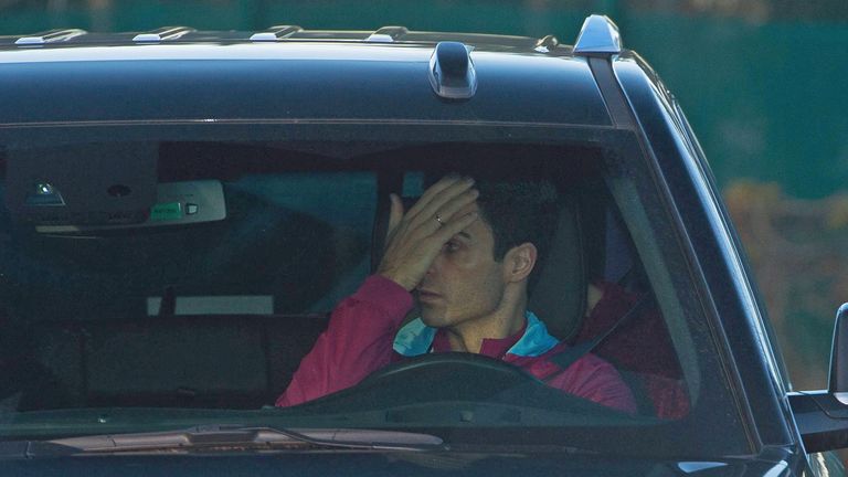 Coach Mikel Arteta covers his face after it was allegedly cut after Lukaku threw a bottle at him during a dressing room fracas
