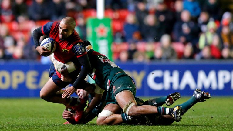 Simon Zebo of Munster is tackled by Mike Williams and Tino Mapapalangi of Leicester Tigers 