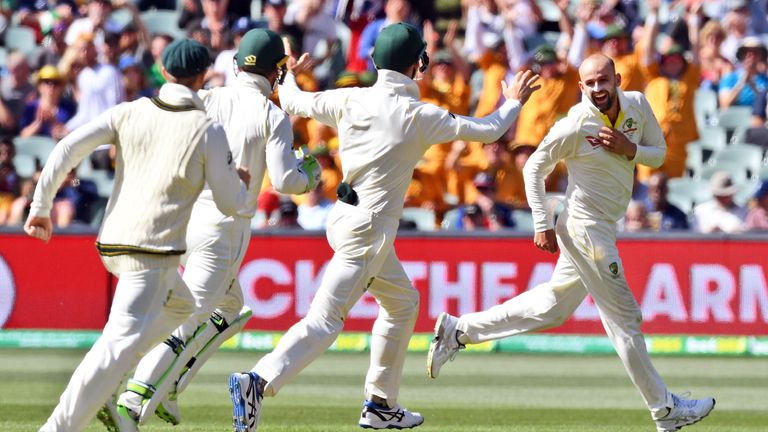 Australian spinner Nathan Lyon (R) is congratulated by teammates after dismissing England batsman Moeen Ali on the third day of the second Ashes cricket Te