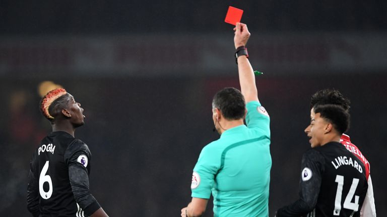 Paul Pogba of Manchester United is shown a red card by referee Andre Marriner for stamping on Hector Bellerin of Arsenal du