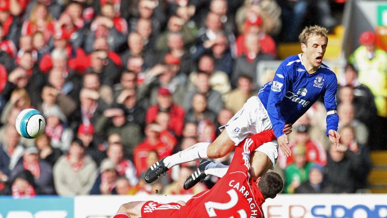 Phil Neville of Everton flies through the air as he is tackled hard by Jamie Carragher 