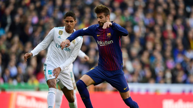 Real Madrid's French defender Raphael Varane (L) vies with Barcelona's Spanish defender Gerard Pique during the Spanish League "Clasico" football match Rea