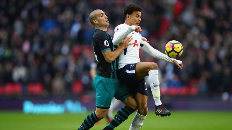 Dele Alli is challenged by Oriol Romeu at Wembley