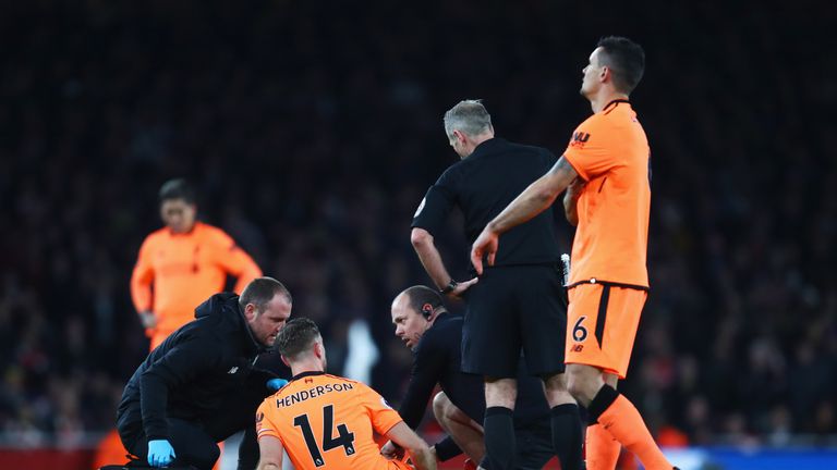 Jordan Henderson receives treatment on the pitch during the Premier League match at the Emirates Stadium