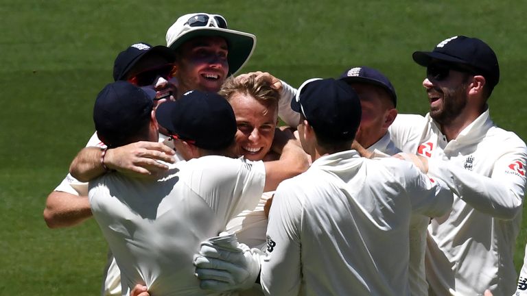 England paceman Tom Curran (C) is congratulated by teammates after having Australia's batsman David Warner caught off a no-ball on the first day of the fou