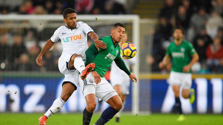 Wayne Routledge challenges Jake Livermore at the Liberty Stadium