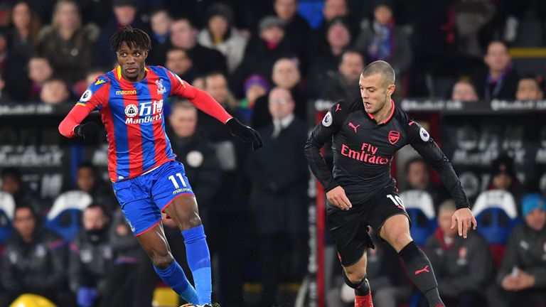 Wilfried Zaha (L) is tracked by Jack Wilshere