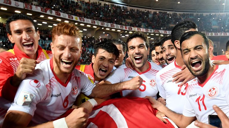 Players of the Tunisian national football team celebrate with their national flag after qualifying for the 2018 World Cup finals