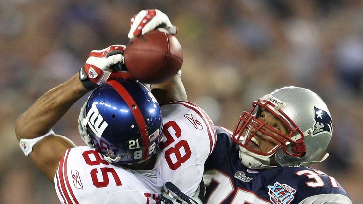 New York Giants' David Tyree catches a 32-yard pass from Eli Manning (not shown) as New England Patriots' Rodney Harrison attempts to intercept