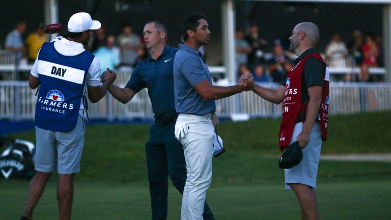 SAN DIEGO, CA - JANUARY 28:  Alex Noren of Sweden and  Jason Day of Australia shake hands with caddies after play was suspend due to darkness after five pl