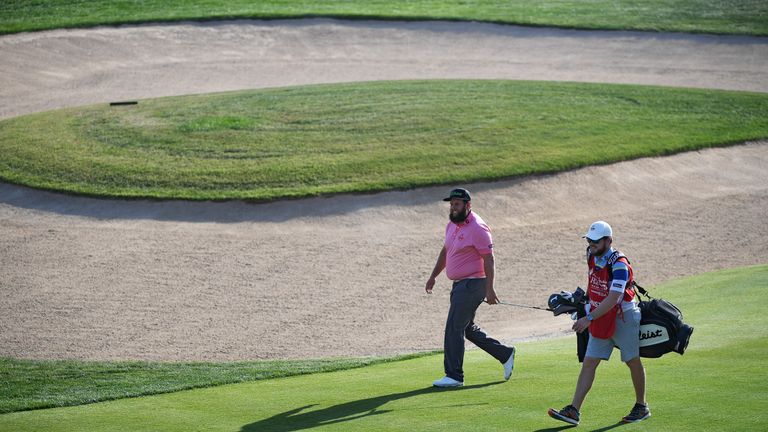 Andrew Johnston of England and his caddie walk on the 18th hole during round three of the Abu Dhabi HSBC Championship