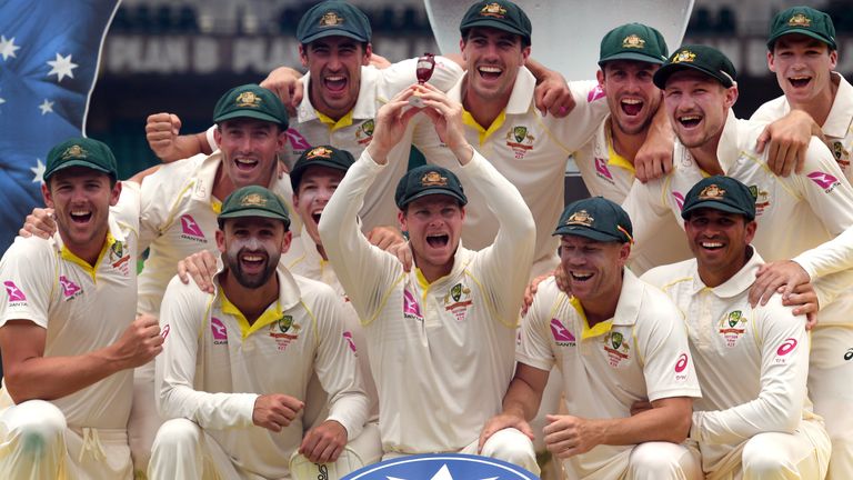Australia's cricket team celebrates after retaining the Ashes trophy, defeating England on the final day of the fifth Ashes cricket Test match at the SCG i