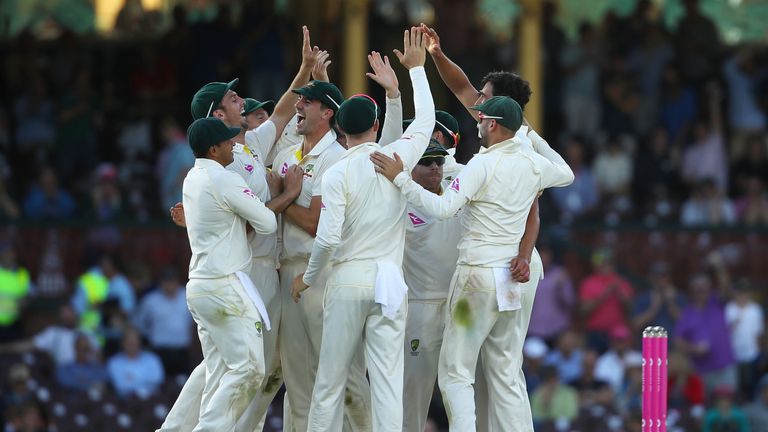 SYDNEY, AUSTRALIA - JANUARY 04:  Mitch Marsh and Mitchell Starc of Australia celebrate with their team mates after combining to take the wicket of Joe Root