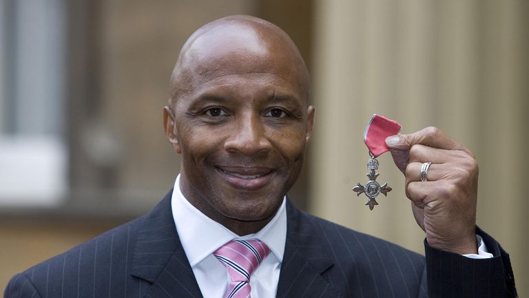 Cyrille Regis stands outside Buckingham Palace after receiving an MBE for services to the voluntary sector and football
