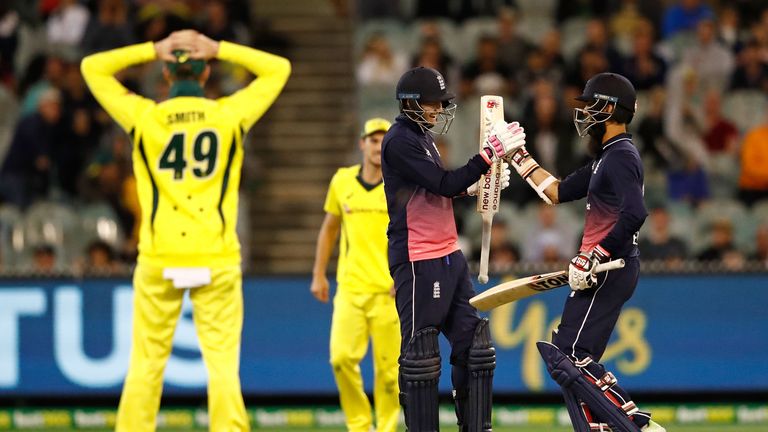 MELBOURNE, AUSTRALIA - JANUARY 14:  Joe Root and Moeen Ali of England celebrate as they hit the winning runs as Australian captain Steven Smith looks on du