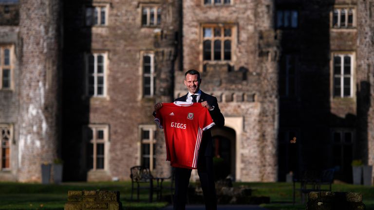 Ryan Giggs poses with a Wales shirt after being unveiled as new manager of the national team during a press conference at Hensol Castle