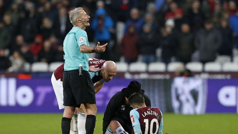 West Ham United's Argentinian midfielder Manuel Lanzini receives medical attention after picking up an injury during the English Premier League football ma
