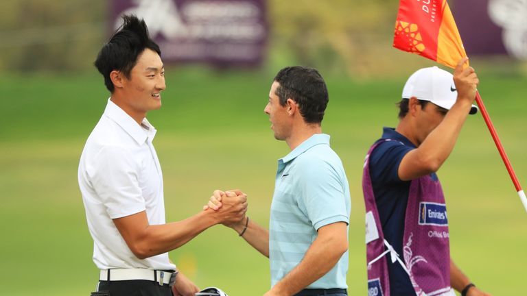 DUBAI, UNITED ARAB EMIRATES - JANUARY 28:  Haotong Li of China (L) shakes hands with Rory McIlroy of Northern Ireland as he celebrates his  victory during 