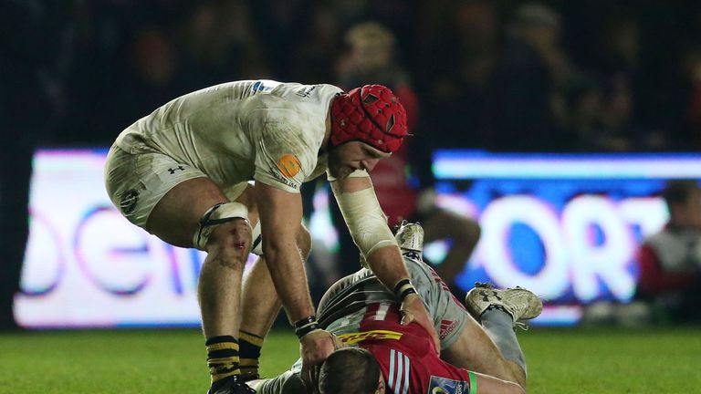 Wasps' James Haskell checks on Harlequins' Jamie Roberts after a late tackle for which he is sent off during the Champions Cup pool one match at Twickenham