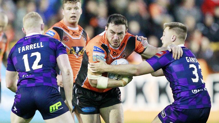 Castleford's Grant Millington tackled by Wigan's Liam Farrell and Josh Ganson