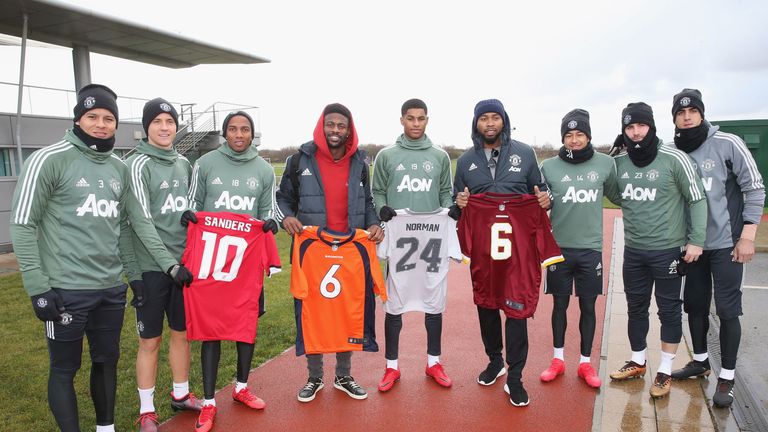 Manchester United players pose alongside NFL stars Josh Norman and Emmanuel Sanders at the Aon Training Complex